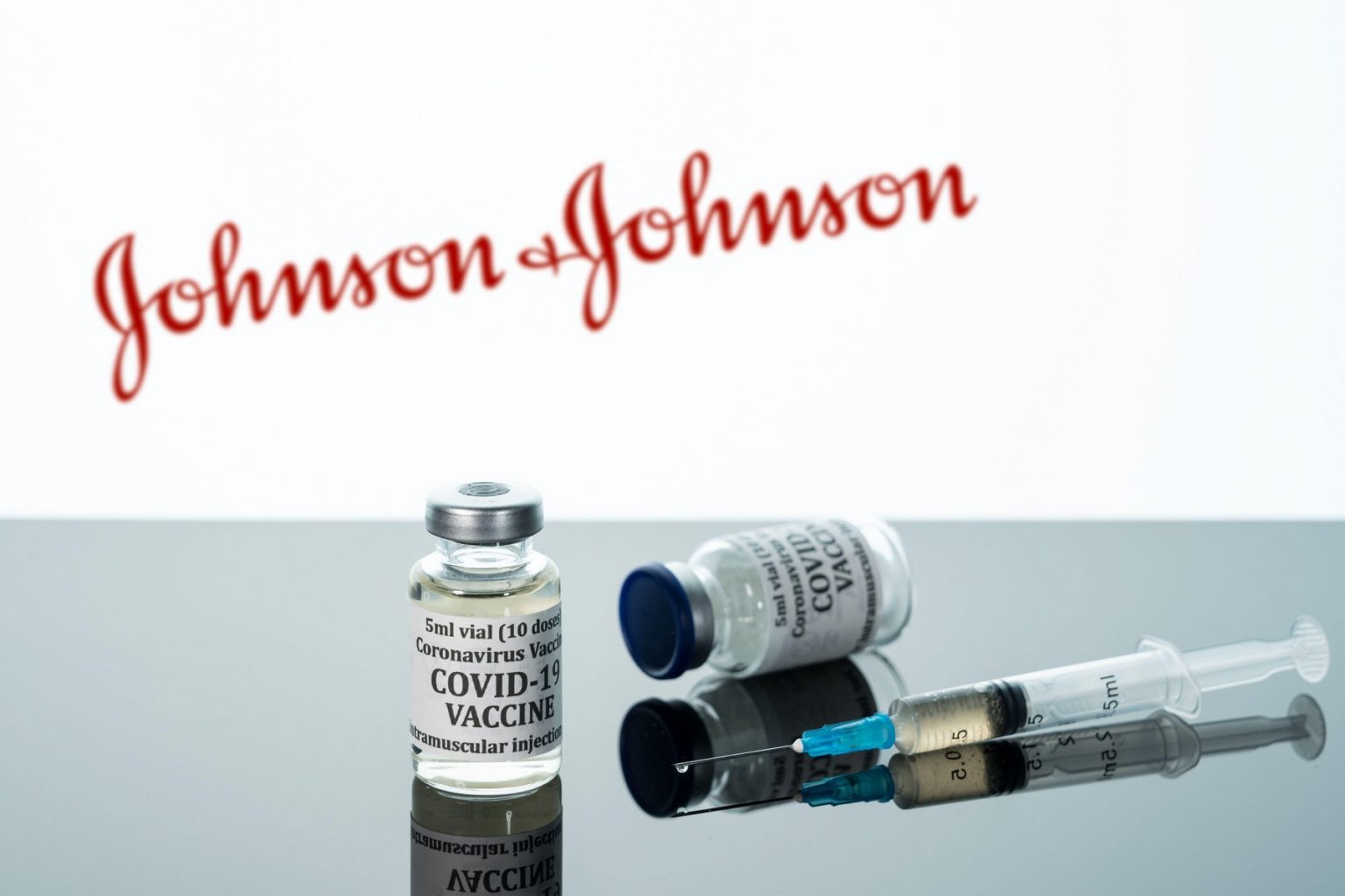 Morgantown, WV - 16 December 2020: Small bottle of coronavirus vaccine with syringe with background of Johnson and Johnson logo - Jurnalul Olteniei – Știri din Craiova și Oltenia