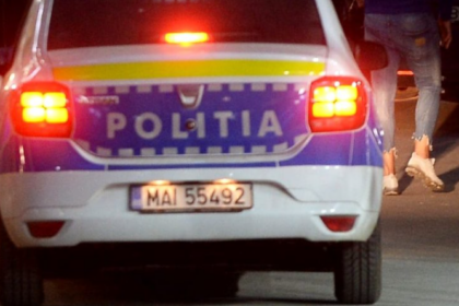 Rear view of a POLITIA police car with flashing red lights, license plate MAI 55492, pedestrians nearby