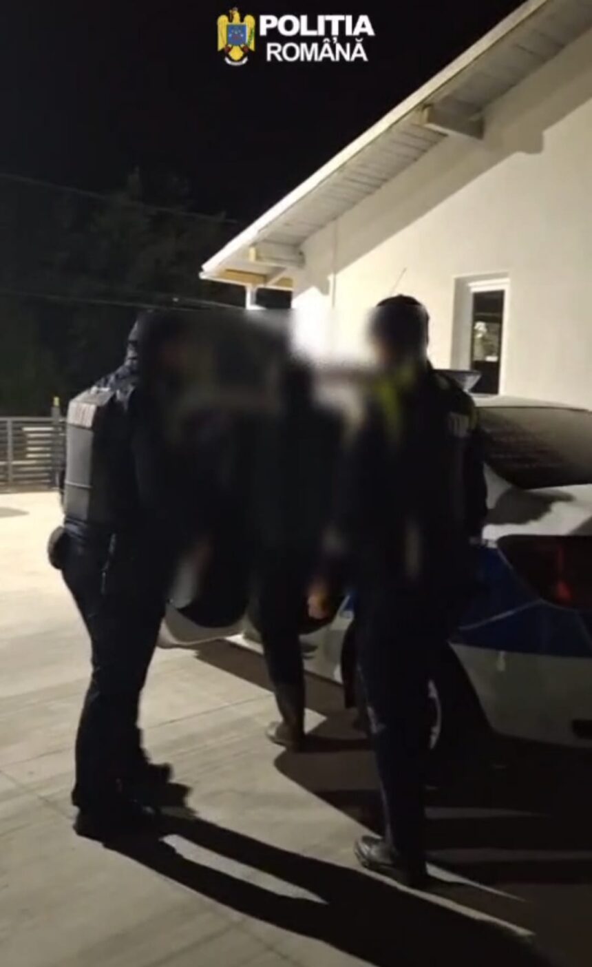 Nighttime scene of Romanian police officers in protective vests detaining a person beside a car outdoors; 'Politia Romana' watermark at top.