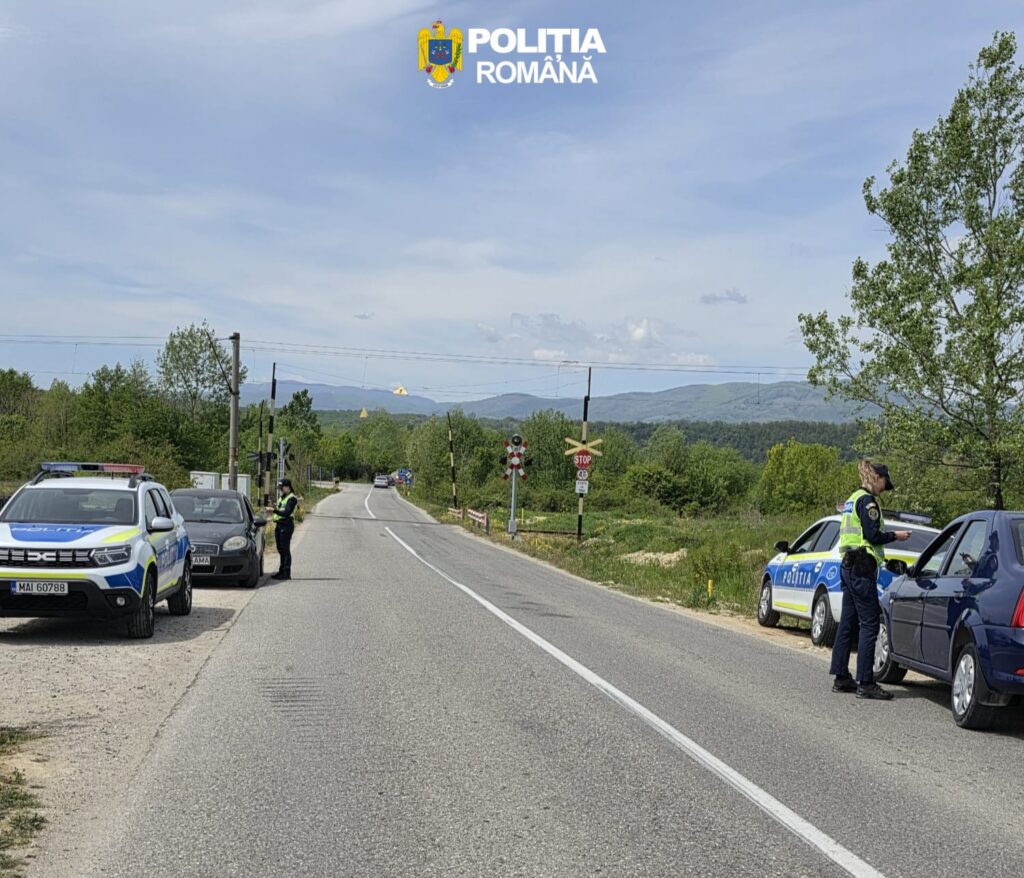 Romanian police checkpoint on a rural road with officers talking to drivers and patrol cars parked on both sides