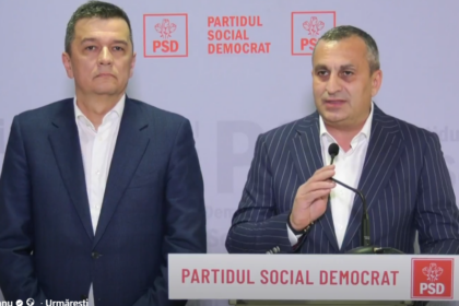 Two men in suits stand at a podium with a microphone, in front of a backdrop and banner reading 'PARTIDUL SOCIAL DEMOCRAT' with PSD logos.