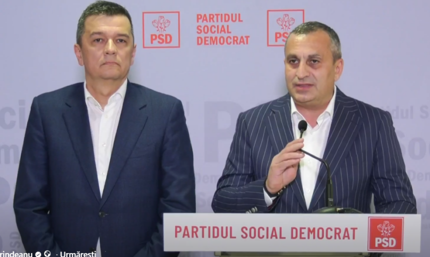 Two men in suits stand at a podium with a microphone, in front of a backdrop and banner reading 'PARTIDUL SOCIAL DEMOCRAT' with PSD logos.