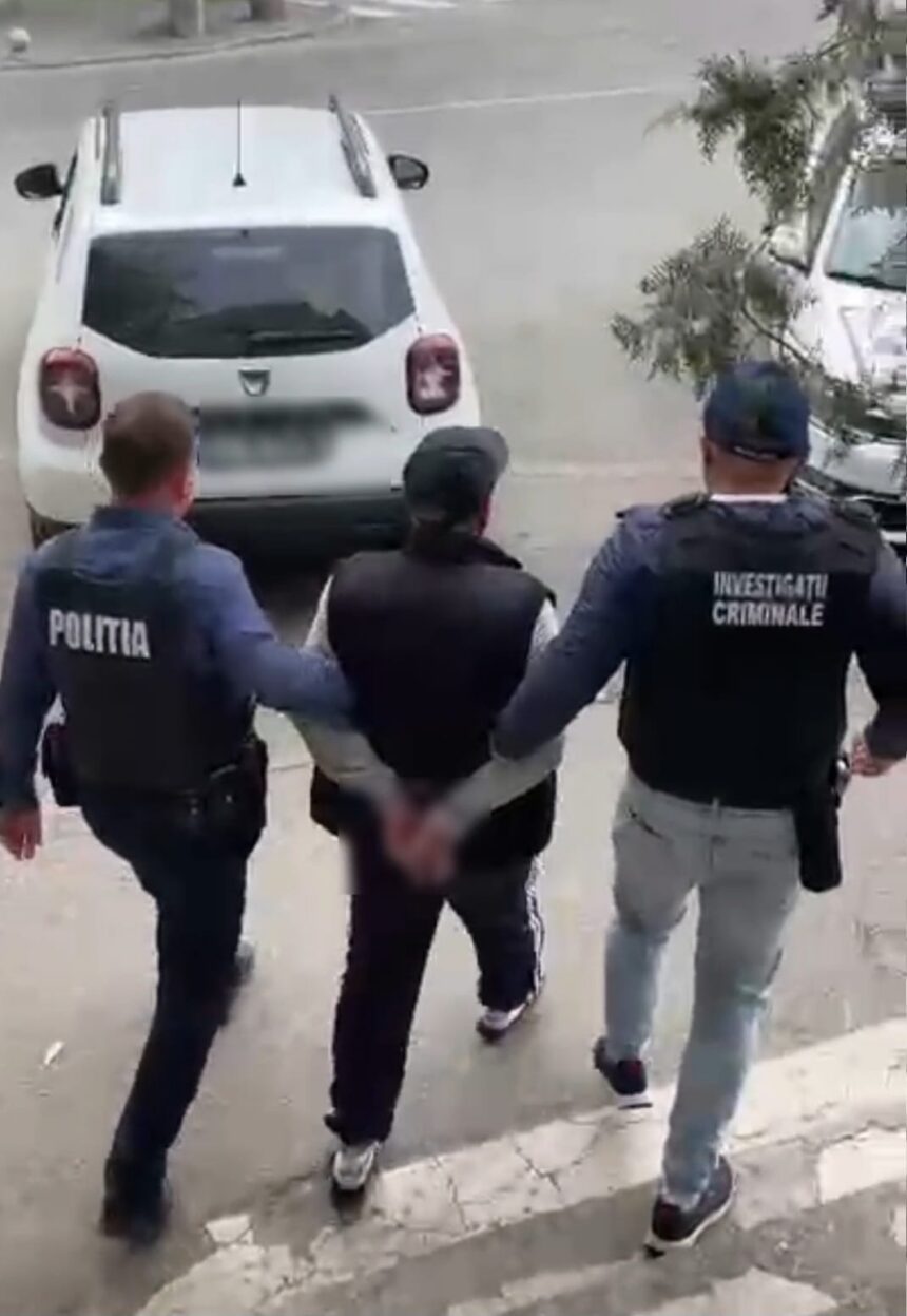 Three officers escort a handcuffed man down a sidewalk toward a white car; vests read 'Politia' and 'Investigatii Criminale' in a street scene.