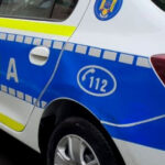 Blue and white Romanian police car with 'Politia' lettering and 112 emergency number on the door side.