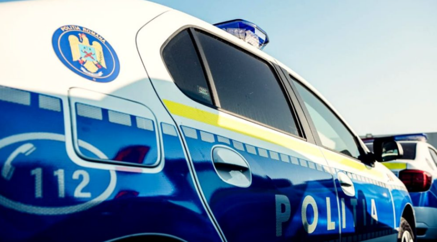 Romanian police car photographed from the side with blue and white livery, emergency 112 mark, and blue roof light