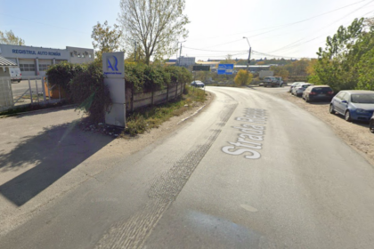 Curved road with parked cars on the right and a building labeled Registrul Auto Român on the left.