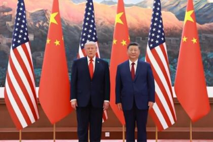 Two world leaders, Donald Trump and Xi Jinping, stand side by side in front of alternating U.S. and Chinese flags during a formal event.