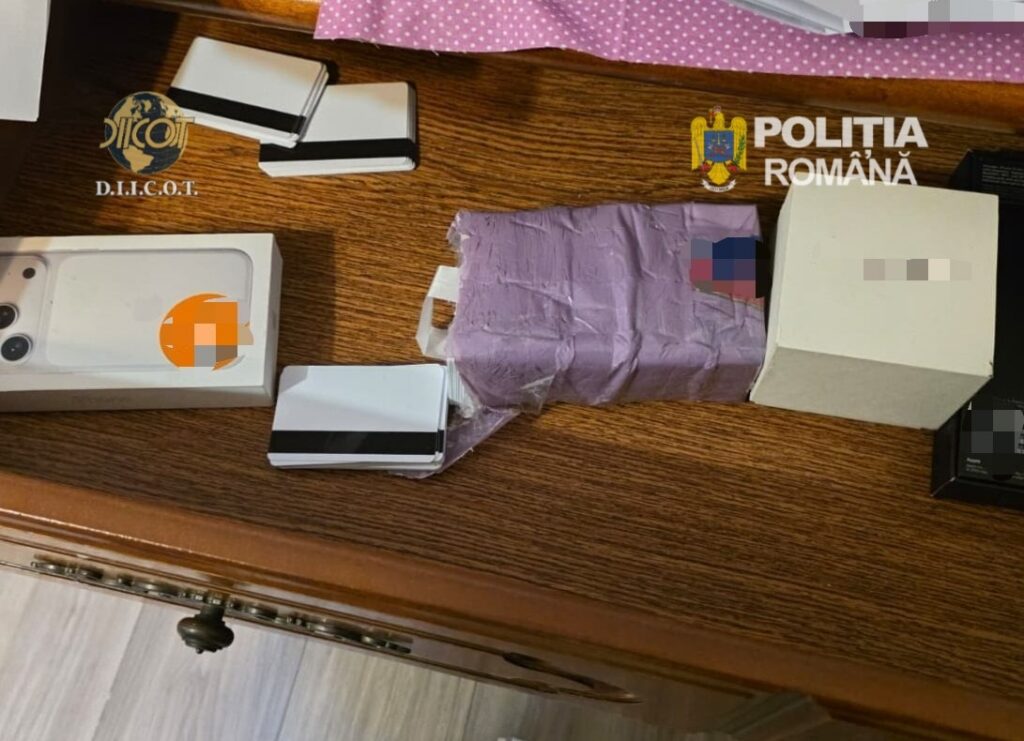 WhatsApp Image 2026-05-14 at 141103 - Jurnalul Olteniei – Știri din Craiova și Oltenia Assorted smartphone boxes and a purple wrapped package on a wooden desk, with DIICOT and Poliția Română logos visible (seizure scene).