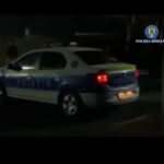 Romanian Police car at night with blue-and-white livery and red taillights visible.