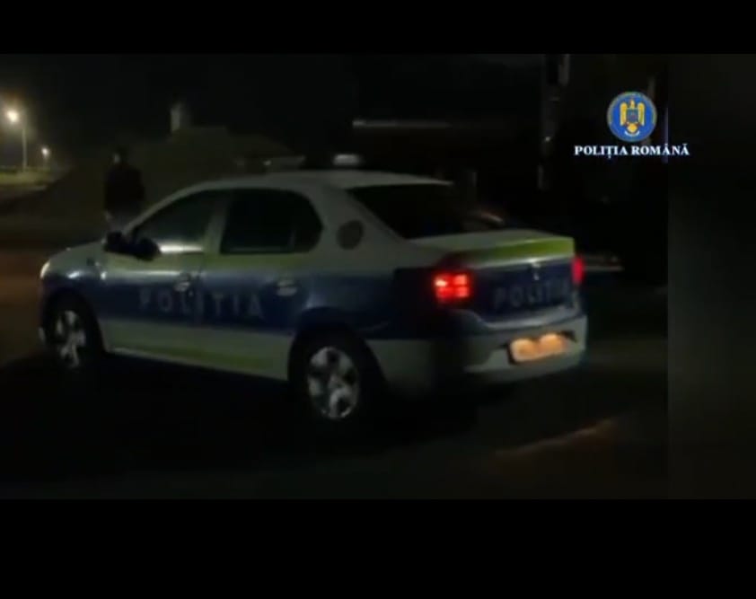 Romanian Police car at night with blue-and-white livery and red taillights visible.