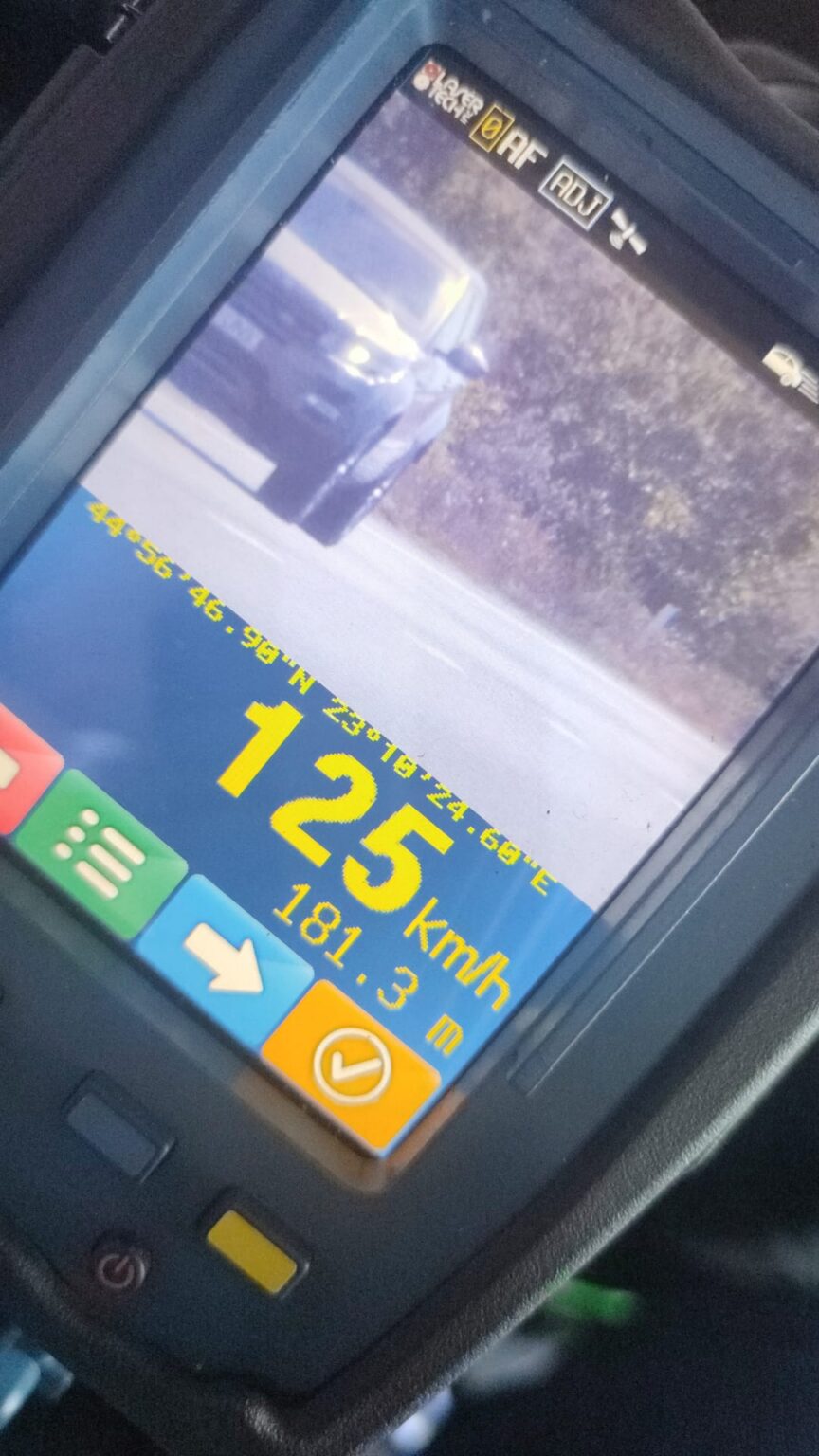 Car dashboard screen showing current speed 125 km/h and distance 181.3 m on a blue/orange display with a truck ahead on a road.