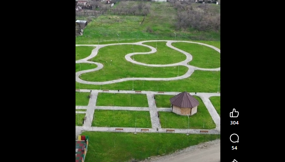 Screenshot 2026-06-15 114849 - Jurnalul Olteniei – Știri din Craiova și Oltenia Aerial view of a park with winding white gravel paths around a small hexagonal gazebo and neat grassy plots with benches.