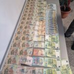 Row of confiscated banknotes (Romanian lei and euros) spread across a table beneath the Poliția Română logo.