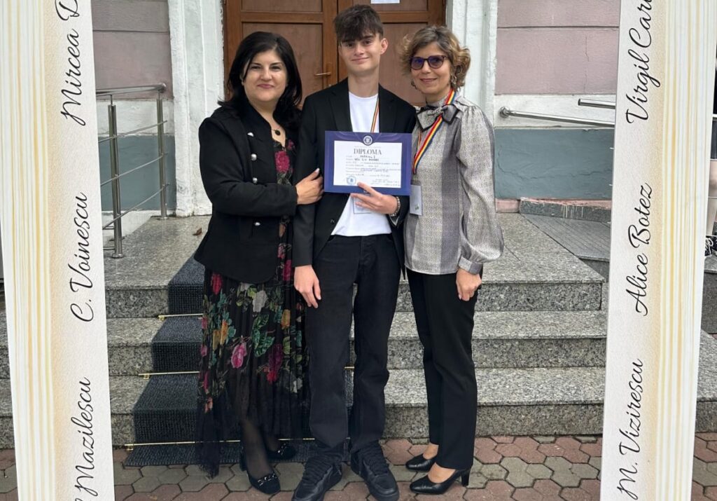 Three people pose on steps outside a building; the young man in the center holds a diploma while two women stand beside him.
