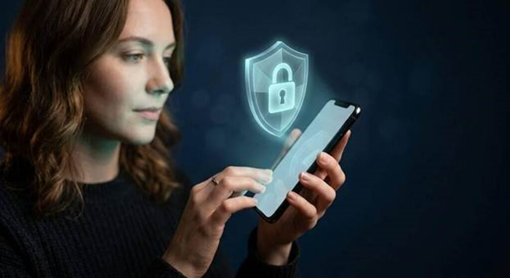 don 2 - Jurnalul Olteniei – Știri din Craiova și Oltenia Woman holding a tablet with a glowing shield and padlock icon to symbolize mobile security.