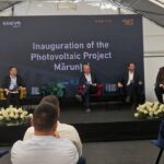 Panel discussion on stage for the Inauguration of the Photovoltaic Project, with a large branded backdrop behind the speakers.