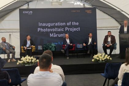 Panel discussion on stage for the Inauguration of the Photovoltaic Project, with a large branded backdrop behind the speakers.