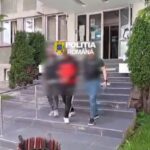Entrance of a police building with 'Politia Romana' sign; blurred individuals descend concrete steps.