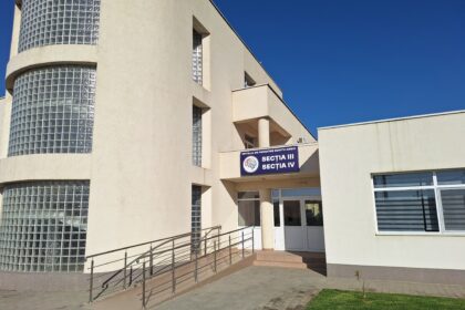 Beige modern hospital building with curved glass block windows and a ramp to the entrance.