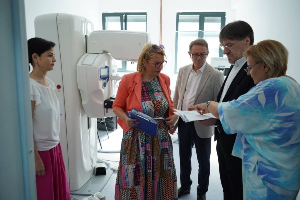 spitalul caracal 1 - Jurnalul Olteniei – Știri din Craiova și Oltenia Group of five adults in a medical imaging room gathered around an MRI scanner, reviewing documents and charts together.