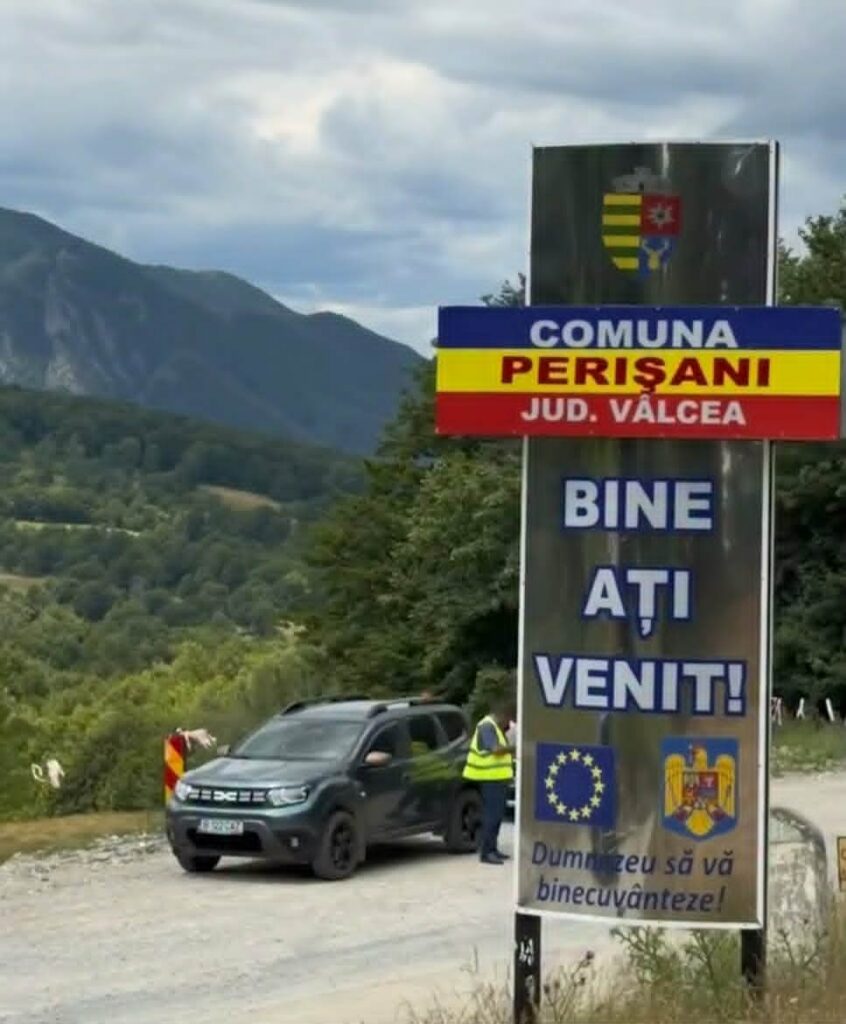 - Jurnalul Olteniei – Știri din Craiova și Oltenia Car at a border checkpoint beside a sign reading 'BINE ATI VENIT!', with EU flag and local emblems against a mountain backdrop.