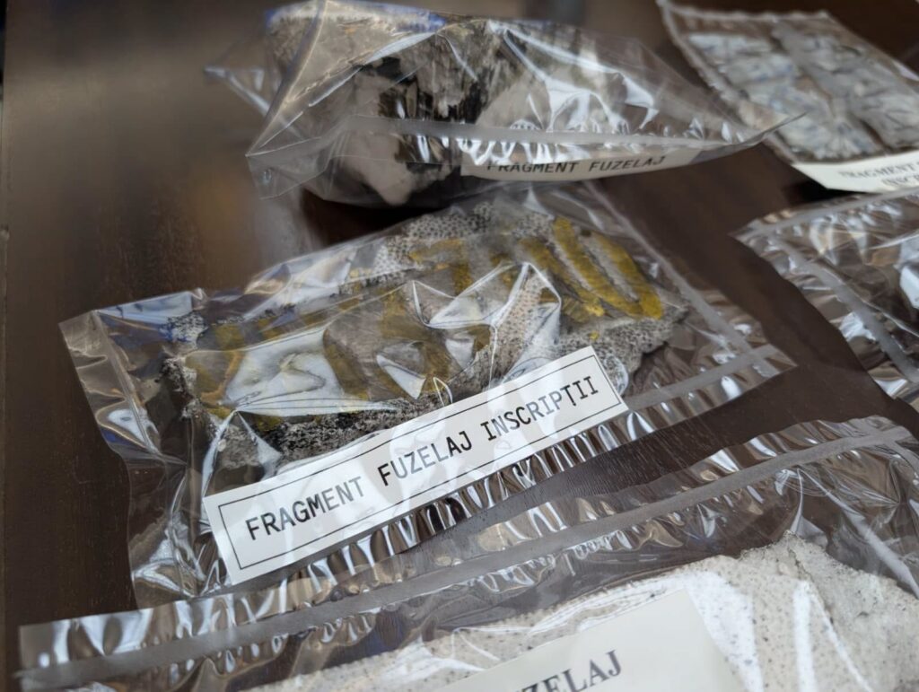 - Jurnalul Olteniei – Știri din Craiova și Oltenia Clear plastic bags on a table containing rock fragments with a label reading 'FRAGMENT FUZELAJ INSCRIPITI' (fuzelage fragments) — likely artifact fragments in a lab setting.