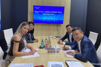 Signing ceremony at a conference table with four professionals signing documents; screen behind reads 'Romanian 10MW/40MWh BESS Signing Event'.