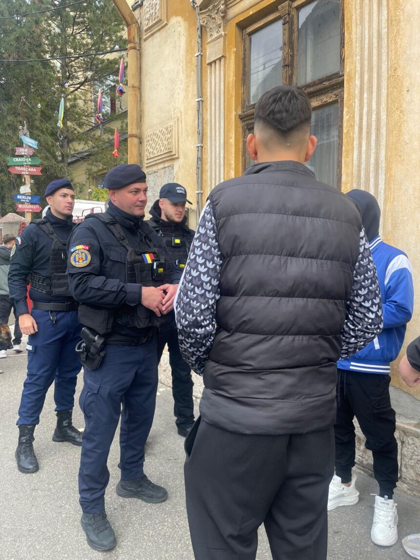Police officers in tactical gear speak with a man in a black puffer jacket on a city street beside a weathered yellow building.