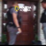 Blurry image of Romanian police officers at a doorway, with the Politia Romana logo visible above them.