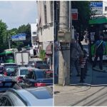 Busy urban street filled with cars, taxis, and a green municipal bus ahead in heavy traffic at a sunny day location with buildings lining the road and people nearby on the sidewalk.