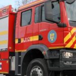 Front and side view of a red fire engine with yellow chevrons and 'POMPIERII' on the side, parked on a road.