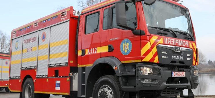 Front and side view of a red fire engine with yellow chevrons and 'POMPIERII' on the side, parked on a road.