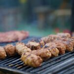 Grilled meatballs cooking on a barbecue grill outdoors.