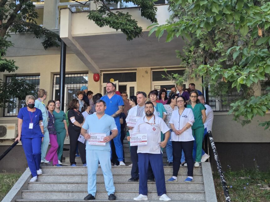 Group of healthcare workers in scrubs standing on building entrance stairs, holding flyers or posters for a blood drive or campaign.