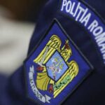 Close-up of Romanian Police patch on a dark blue uniform, showing the national emblem and POLITIA ROMANA text.