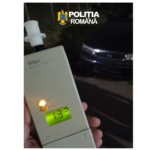 Handheld Dräger breathalyzer with a lit green display reading 1.33, held by a person, Romanian police logo at the top of the image.