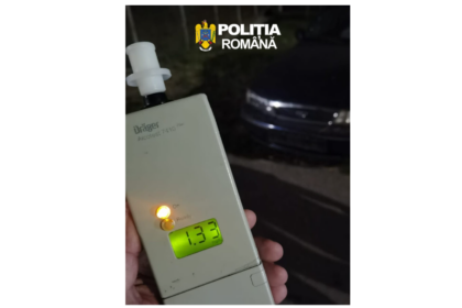Handheld Dräger breathalyzer with a lit green display reading 1.33, held by a person, Romanian police logo at the top of the image.