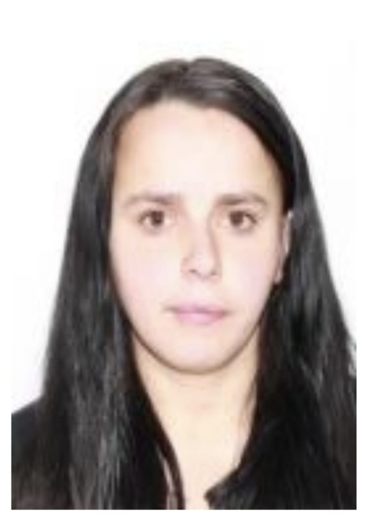 Portrait of a young woman with long dark hair facing the camera against a white background, neutral expression.