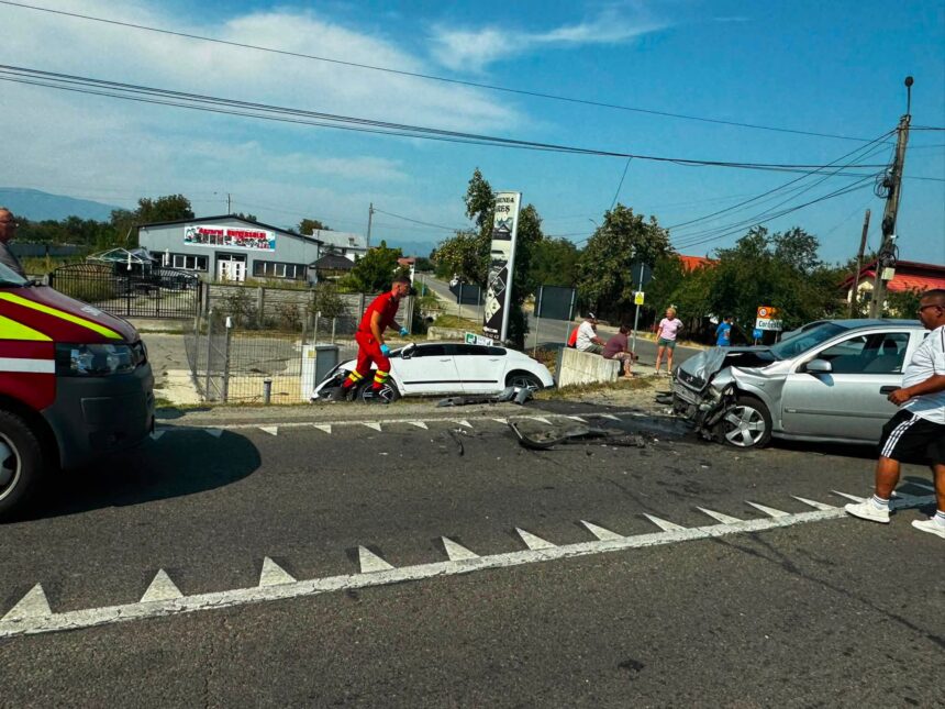 Emergency responders and bystanders at a road collision with a damaged white car and debris on the pavement. wires overhead.