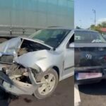 Silver sedan with severe front-end damage after a collision; debris scattered on the roadway.