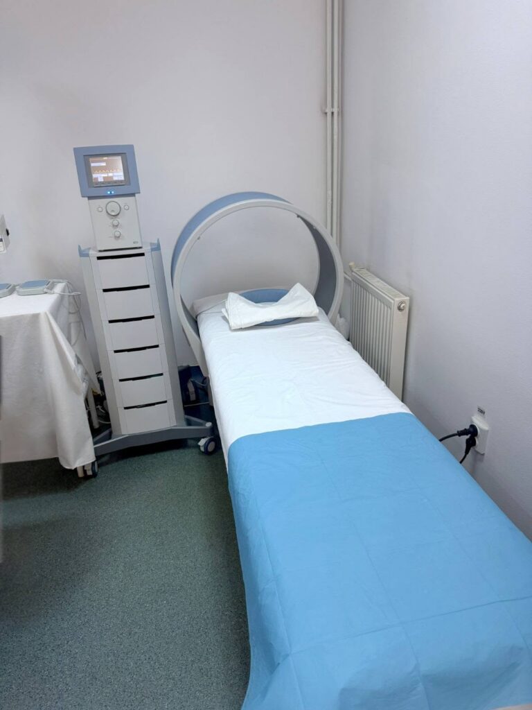 MRI room with a circular gantry and a blue-covered patient bed ready for imaging.