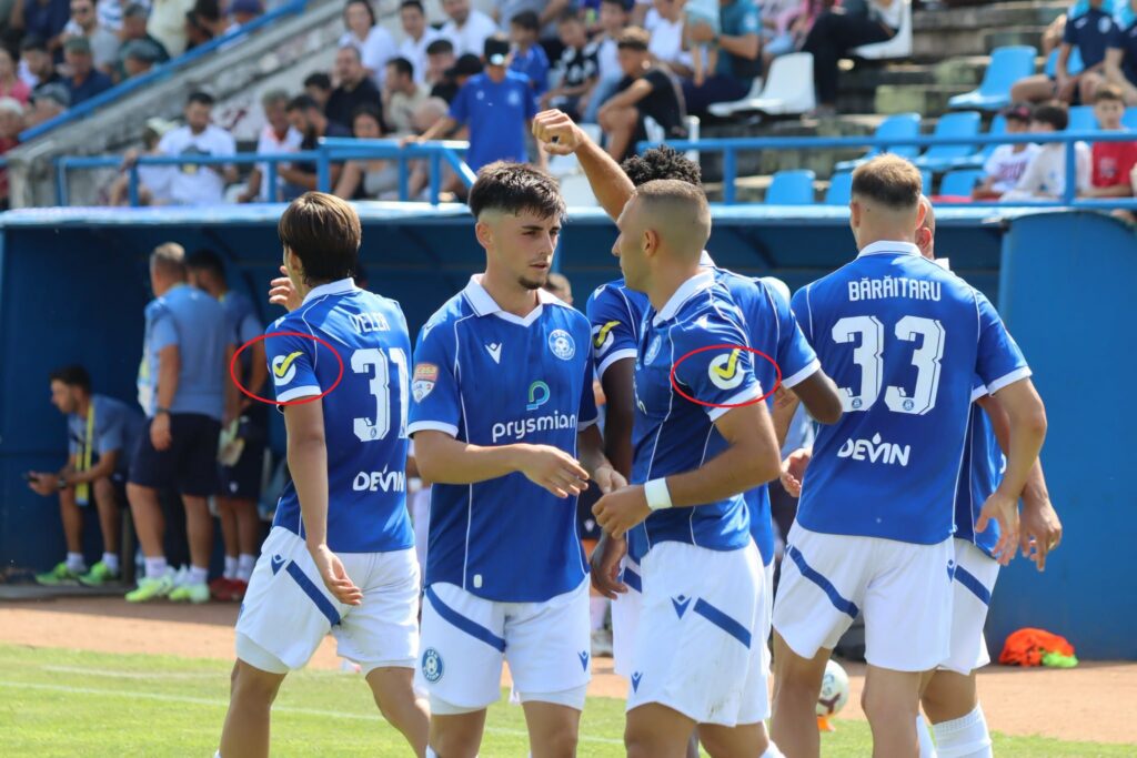 csm insemn electoral - Jurnalul Olteniei – Știri din Craiova și Oltenia Soccer players in blue uniforms celebrate on the field near the sideline, with spectators in the stands behind them.