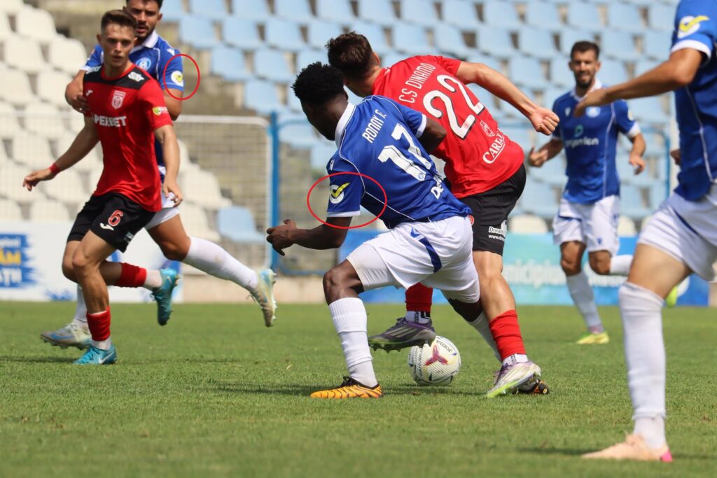 csm insemn electoral 2 - Jurnalul Olteniei – Știri din Craiova și Oltenia Soccer match scene with players in blue and red jerseys contesting the ball on a green pitch, stadium seating in the background.