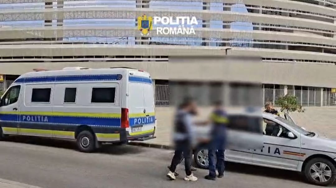 Romanian police van and marked patrol car parked outside a modern building; three blurred individuals stand nearby.
