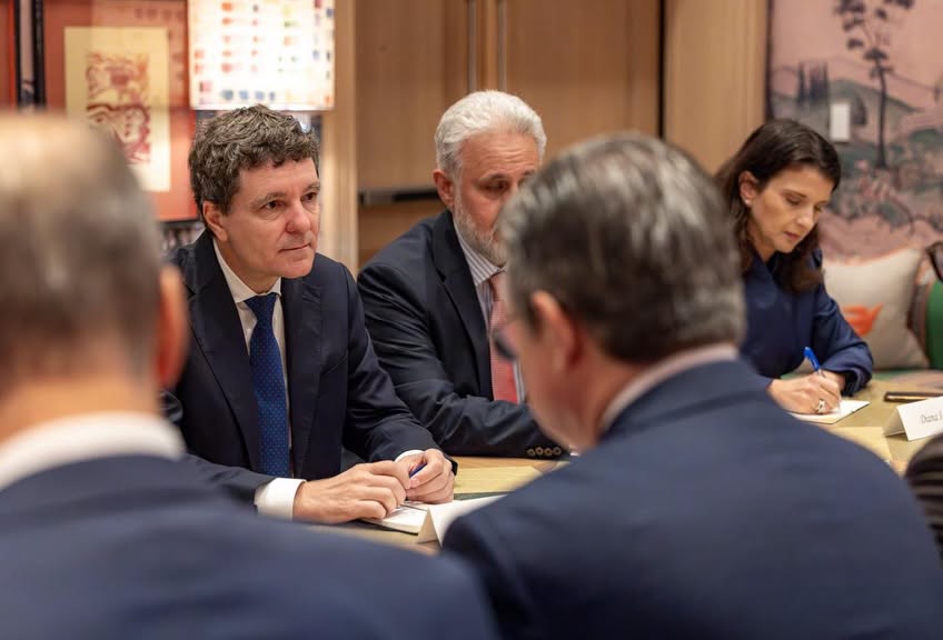 Nicușor Dan, mesaj la Adunarea Generală ONU - Jurnalul Olteniei – Știri din Craiova și Oltenia Group of professionals in a meeting around a conference table; man in a blue suit speaks as others listen.