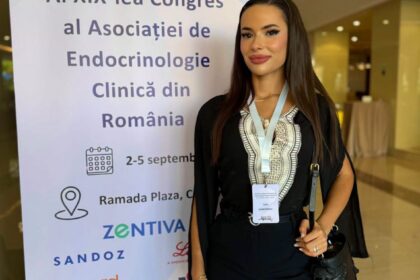 Woman standing next to a conference banner for AI XIX-lea Congres al Asociatiei de Endocrinologie Clinica din Romania, wearing a lanyard badge.