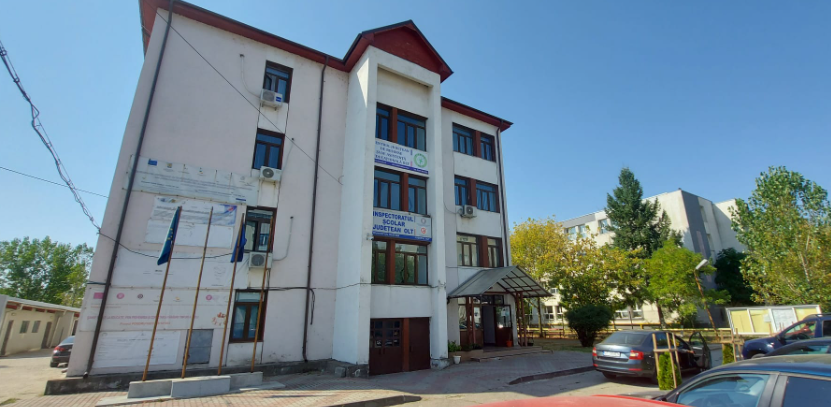 Screenshot 2026-09-01 100117 - Jurnalul Olteniei – Știri din Craiova și Oltenia Three-story white building with banners and a glass entrance, cars parked in front under a blue sky isn’t