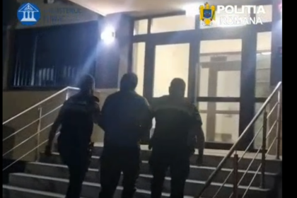 Three men walking up an outdoor staircase toward a glass door at night, railing on both sides.