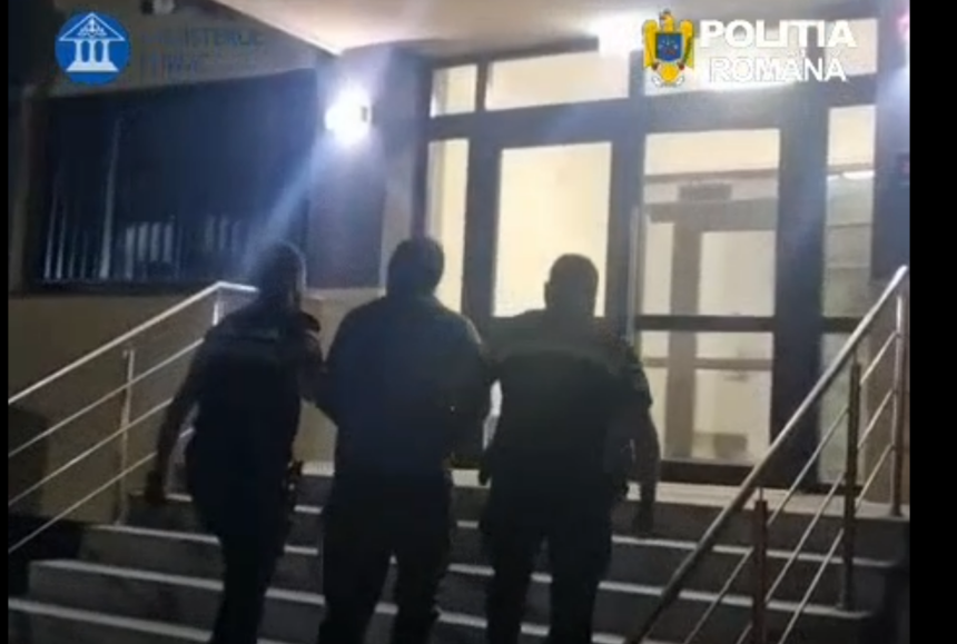 Three men walking up an outdoor staircase toward a glass door at night, railing on both sides.