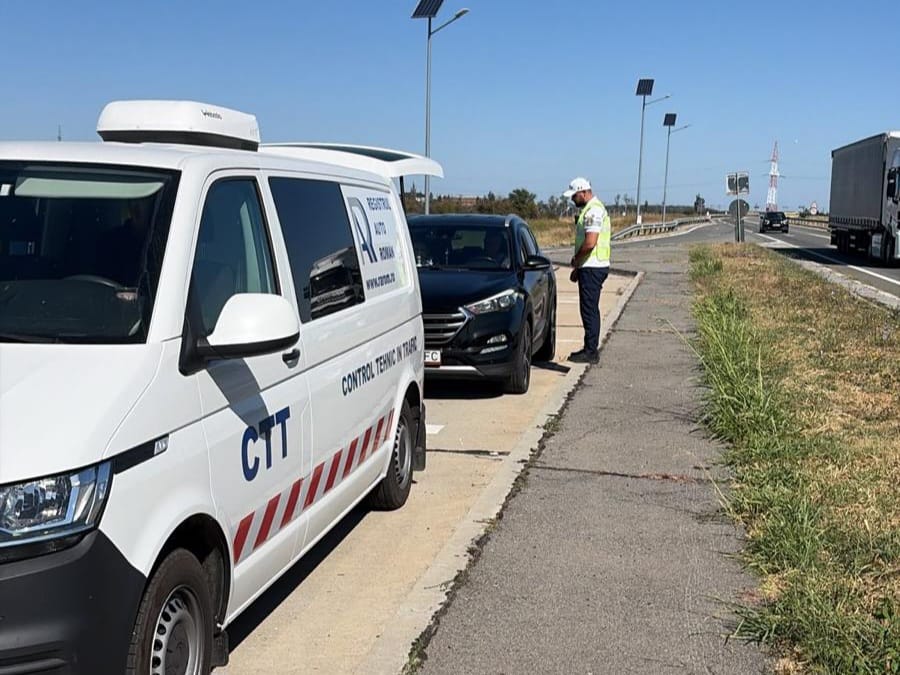 White inspection van labeled CT T and a man in a high-visibility vest checks a black car on the highway shoulder during a roadside inspection.